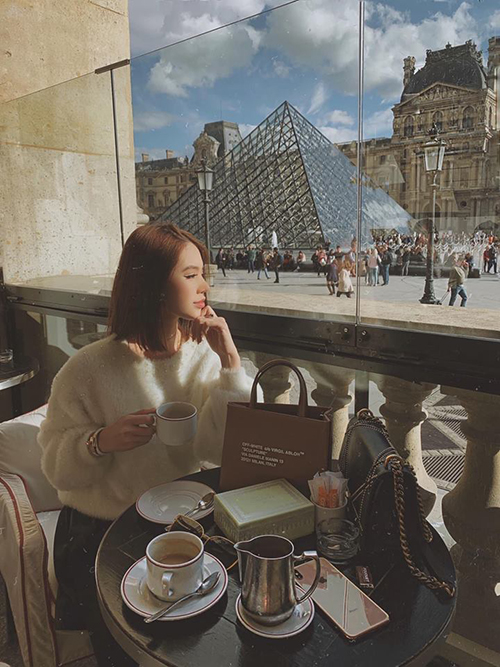 Jolie Nguyễn thảnh thơi uống cà phê trước bảo tàng Louvre (Pháp) trong chuyến du lịch Paris, không quên check in ở tháp Eiffel nổi tiếng. 