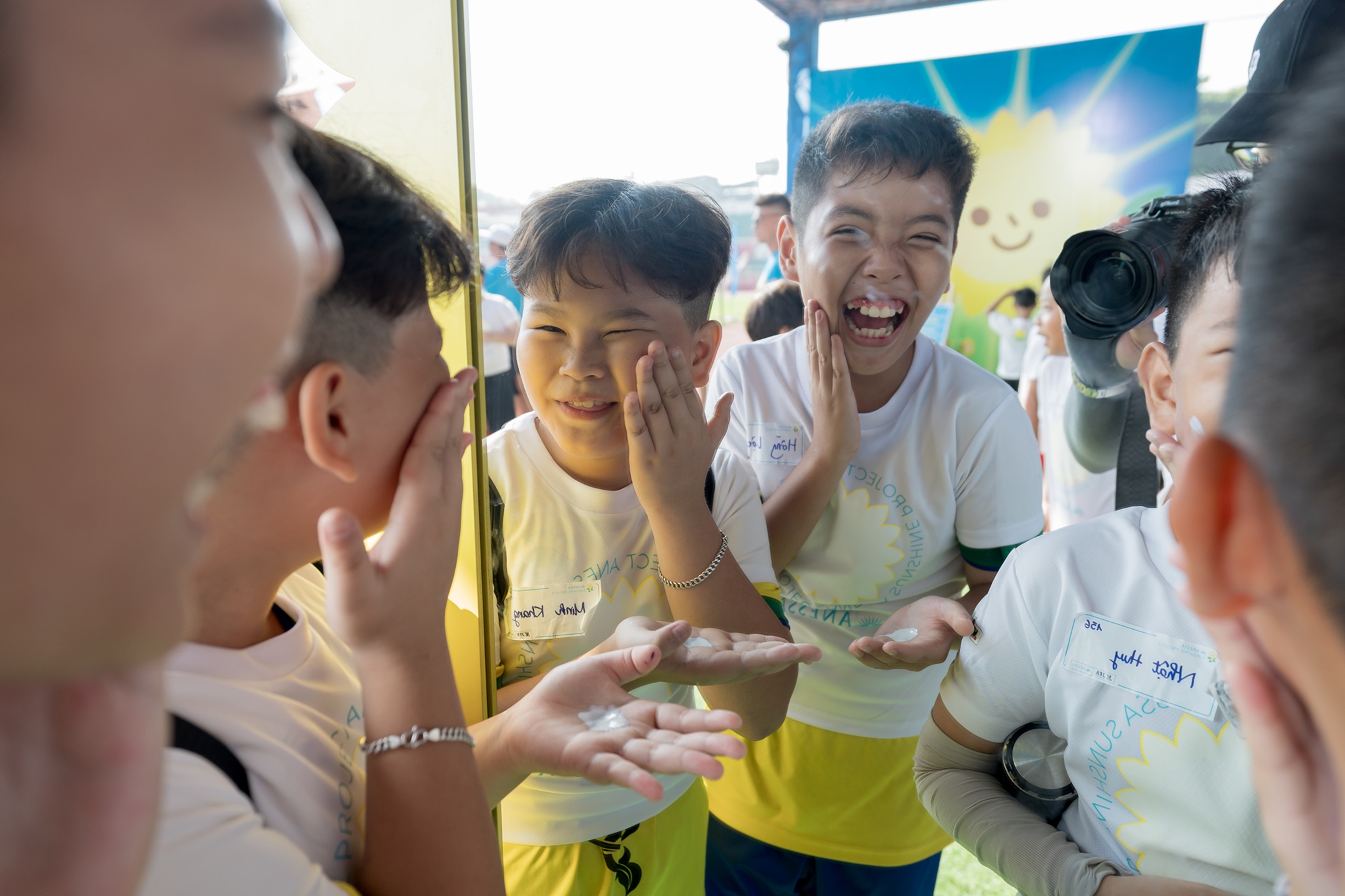 Những bạn nhỏ tham dự được hướng dẫn cách bôi kem chống nắng đúng cách trước khi tham gia hoạt động ngoài trời